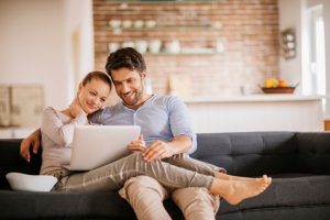 Close up of a happy young couple using laptop at home